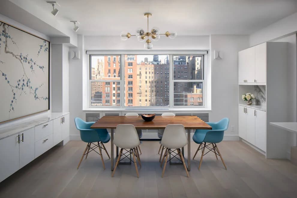 Renovated Park Avenue apartment dining room with prewar Manhattan co-op buildings through the window — Grandeur Hills Group, NYC