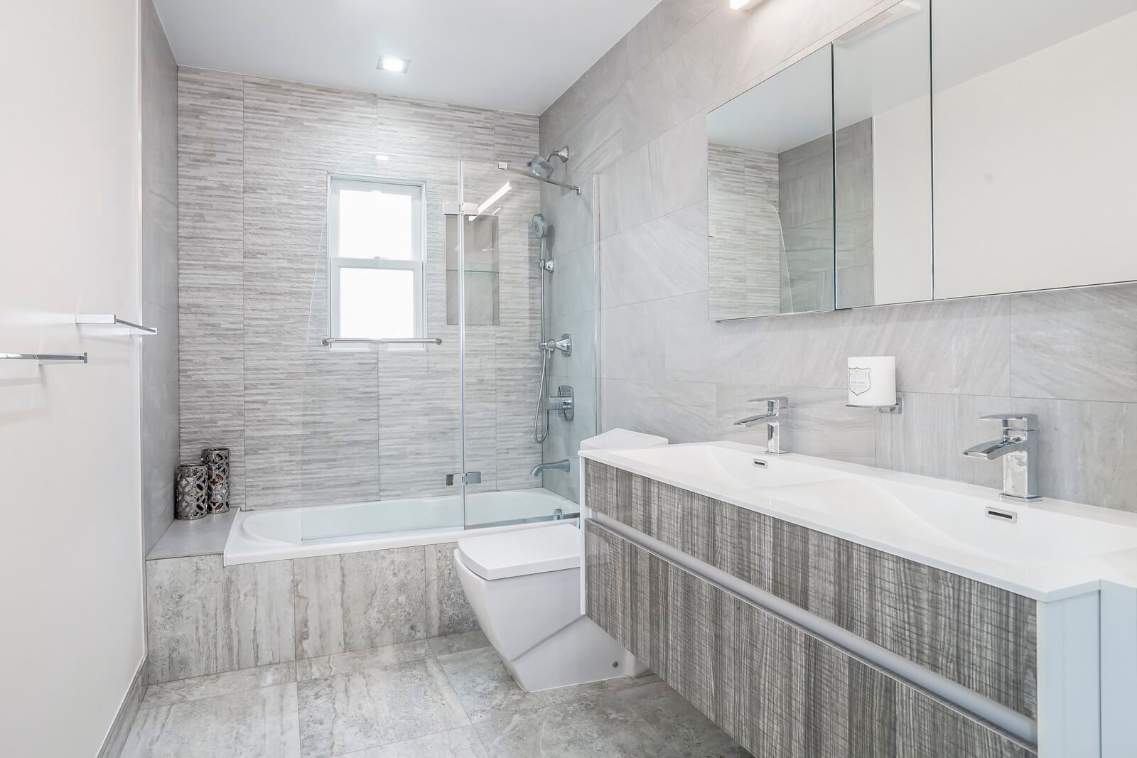 Although this bathroom is small, it doesn't look cramped. Our interior designers placed only the most essential pieces of furniture and sanitary ware in this bathroom. Thanks to this approach, the bathroom looks spacious. Besides, light plays a big role too. During the day, the bathroom receives sunlight through the windows, and in the evening, the bathroom is flooded with artificial light from the numerous lamps mounted on the walls and ceiling. We're here to help you make your bathroom as fully functional and attractive as this one!