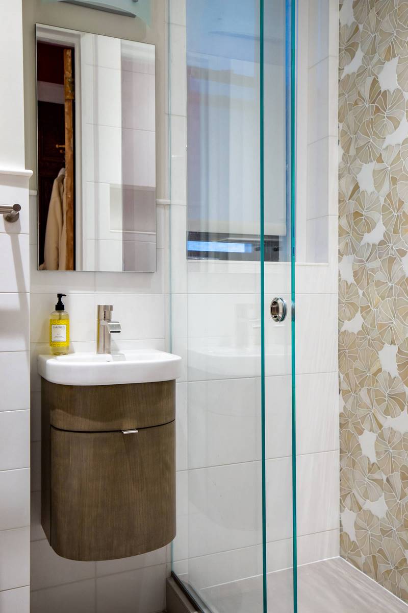 The abundance of glass and mirrored surfaces gives this bathroom not only additional light reflected from artificial light sources, but also a kind of tenderness and warmth, thanks to which the bathroom becomes welcoming and attractive. The transparent surfaces are perfect for wet rooms where water is the main focus of attention. Also pay attention to adding to the interior some blue color that gives natural features to the bathroom. Make your bathroom interior stand out with the best Grandeur Hills Group interior designers!